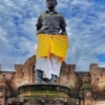 Patung I Gusti Ngurah Rai yang mengenakan kain adat Bali berwarna kuning dan putih,