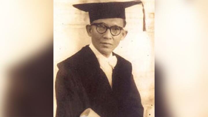 Wiyoto Wiyono mengenakan toga wisuda dan kacamata dalam foto hitam-putih