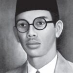 Potret hitam putih WR Soepratman memakai peci dan kacamata bundar.