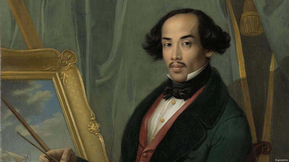 Potret Raden Saleh sedang melukis, mengenakan jas hijau dan dasi kupu-kupu.