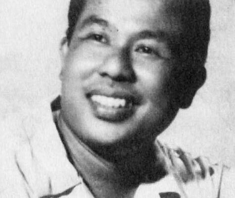 Potret Djamaluddin Malik mengenakan jas, tersenyum di depan kamera
