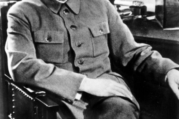 Josef Stalin duduk di kursi dengan seragam khas pemimpin Soviet