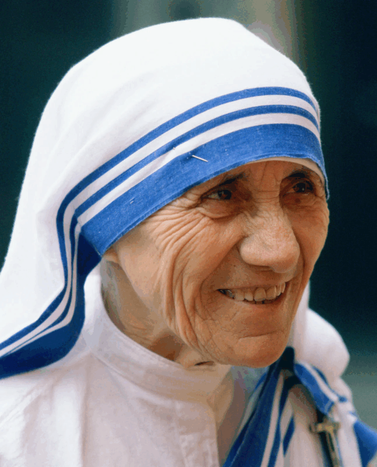 Mother Teresa mengenakan sari putih bergaris biru sambil tersenyum
